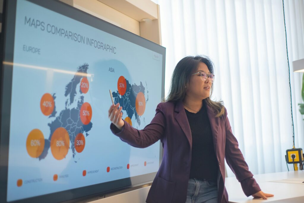 Woman giving a presentation on Technical SEO with a world map infographic on a large screen.